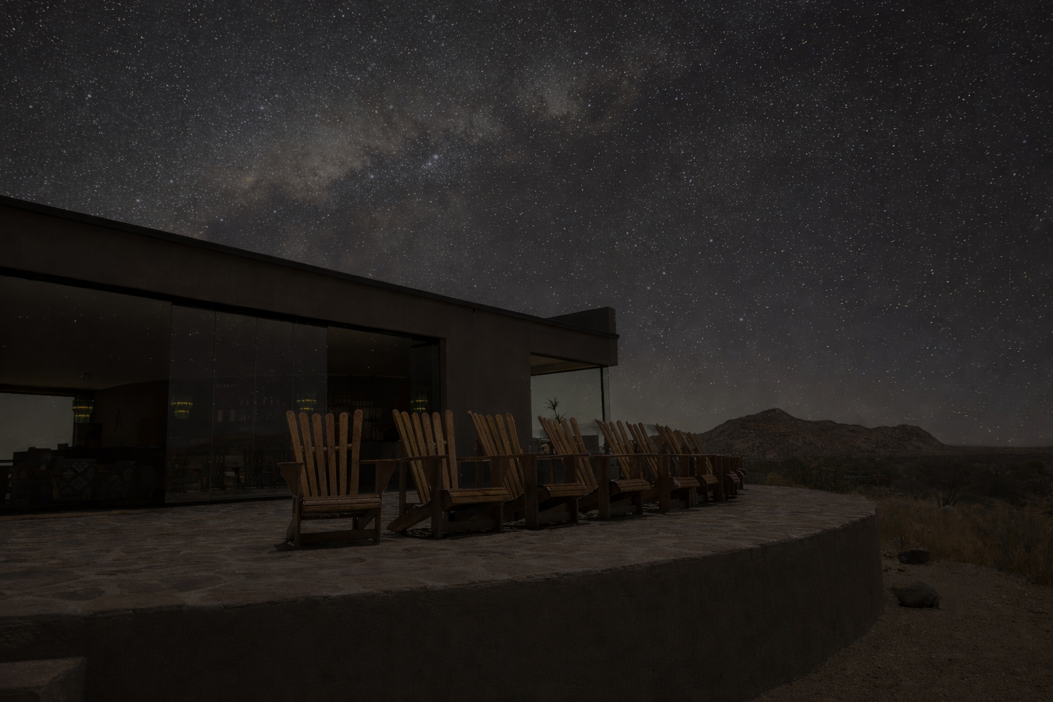 Lounge chairs with mountain views at Hohenstein Lodge at night